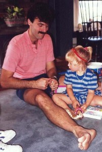 Caitlin and her dad open a present (a Barbie) on her birthday.
