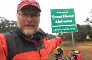 Dave Klein takes a selfie at the "welcome to Alabama" sign