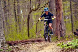 Kacie Kruger, a Tour De Tush Participant, goes over a hill on her mountain bike
