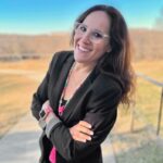 Flor Leibaschoff with arms crossed smiling at the camera